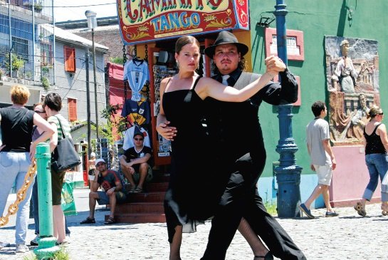 Tango-Tanzpaar im Viertel La Boca in Buenos Aires zwischen bunten Häusern