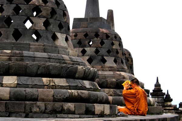 Ein betender Mönch an der Borobudur Tempelanlage auf Java Ein betender Mönch an der Borobudur Tempelanlage auf Java