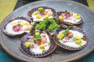 Frisch zubereitete Jakobsmuscheln nach peruanischer Art, serviert mit typischen Zutaten der peruanischen Küche.
